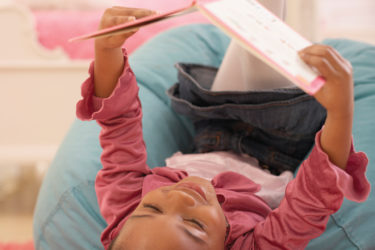 Little girl reading in bed