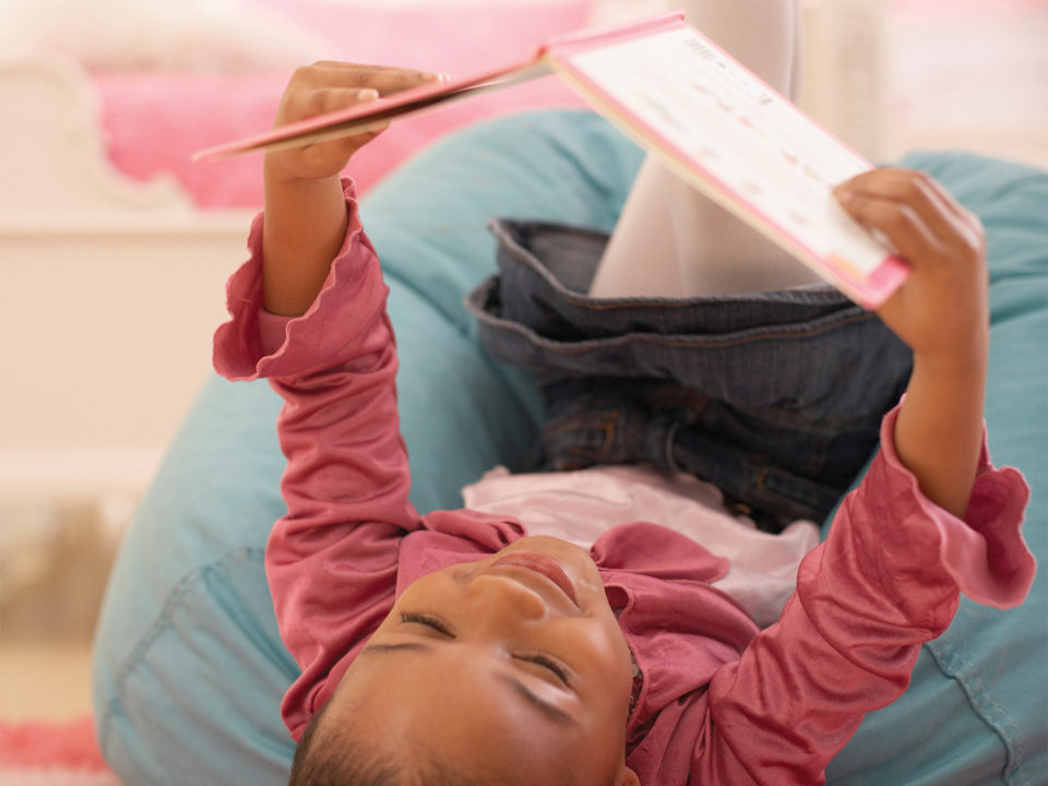 Little girl reading in bed