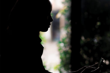 Girl in dark, looking at phone