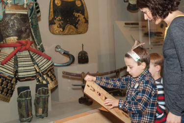 Family looking at Samurai Exhibit