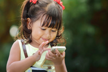 Little girl playing on smartphone