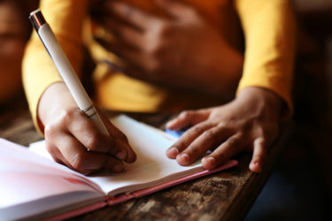 Mother and child writing in notebook