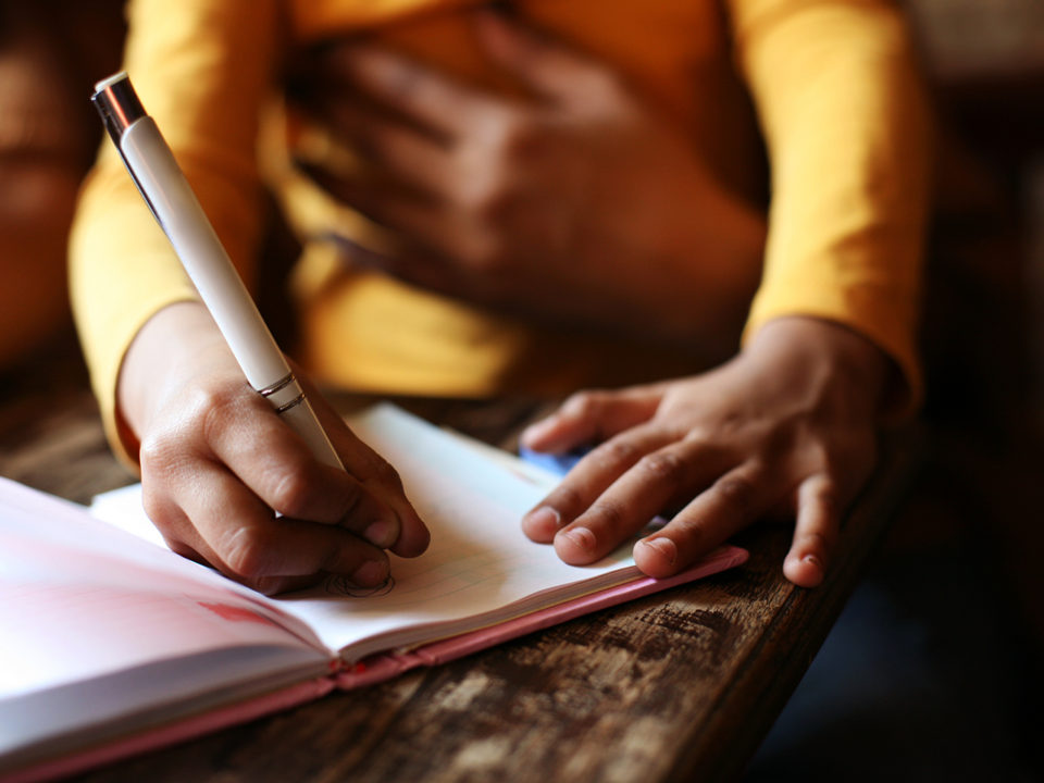 Mother and child writing in notebook