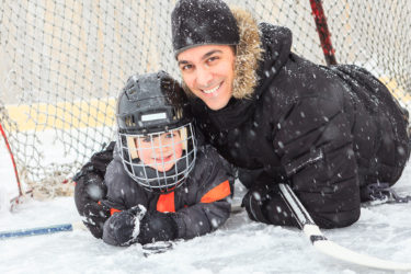 Father and child under hockey net