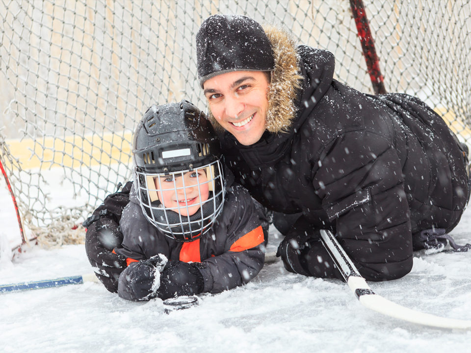 Father and child under hockey net