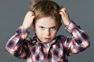 Little boy scratching head