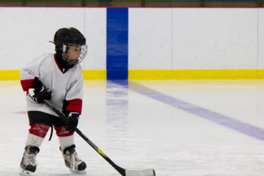 Little boy playing ice hockey