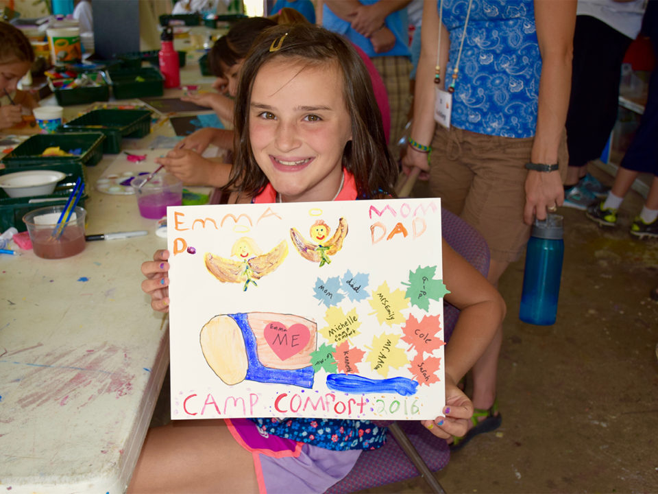 Little girl with a drawing at camp