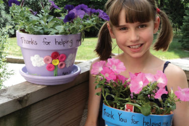 Girl with homemade flower pots for her teacher gifts