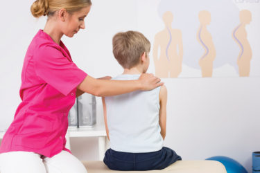Doctor checking child's back