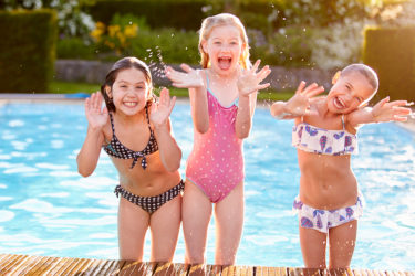 Group Of Girls Playing In Outdoor Swimming Pool