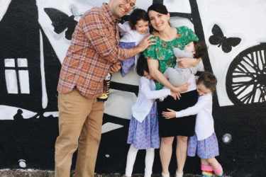 Betany Coons and family in front of a mural