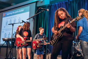 Kids performing on stage through Little Kids Rock