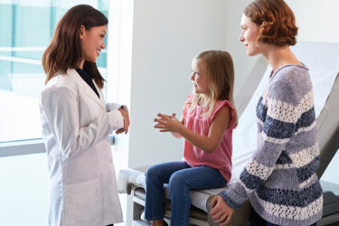 Pediatrician Meeting With Mother And Child In Exam Room
