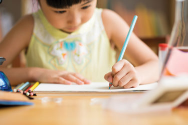 Girl at her desk writing paper