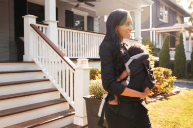 mom walking outside with her baby strapped to her chest