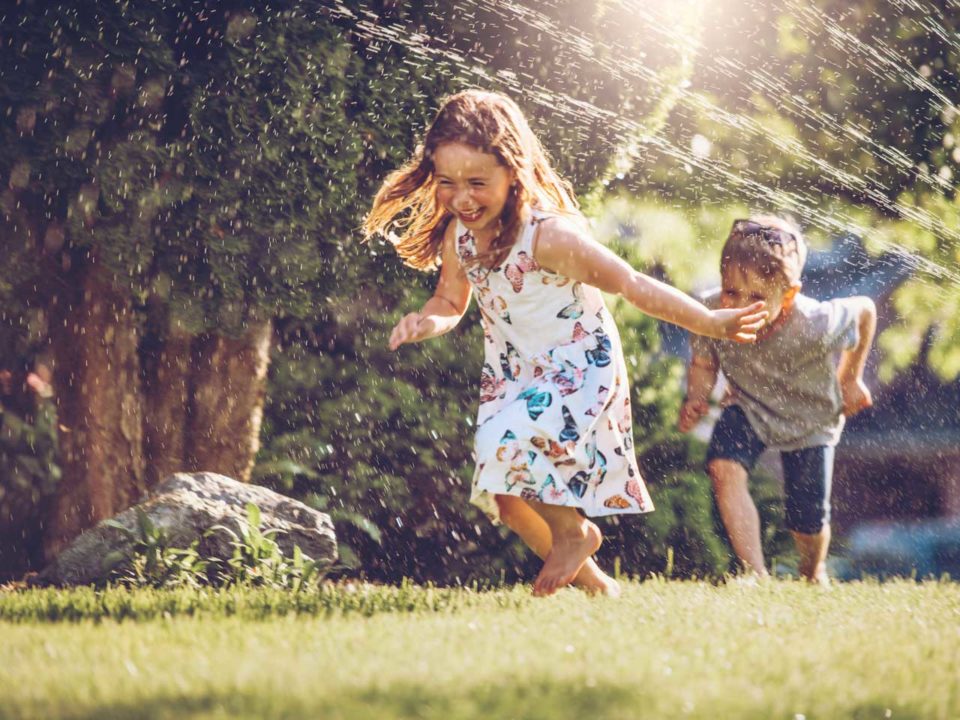 kids running in sprinkler