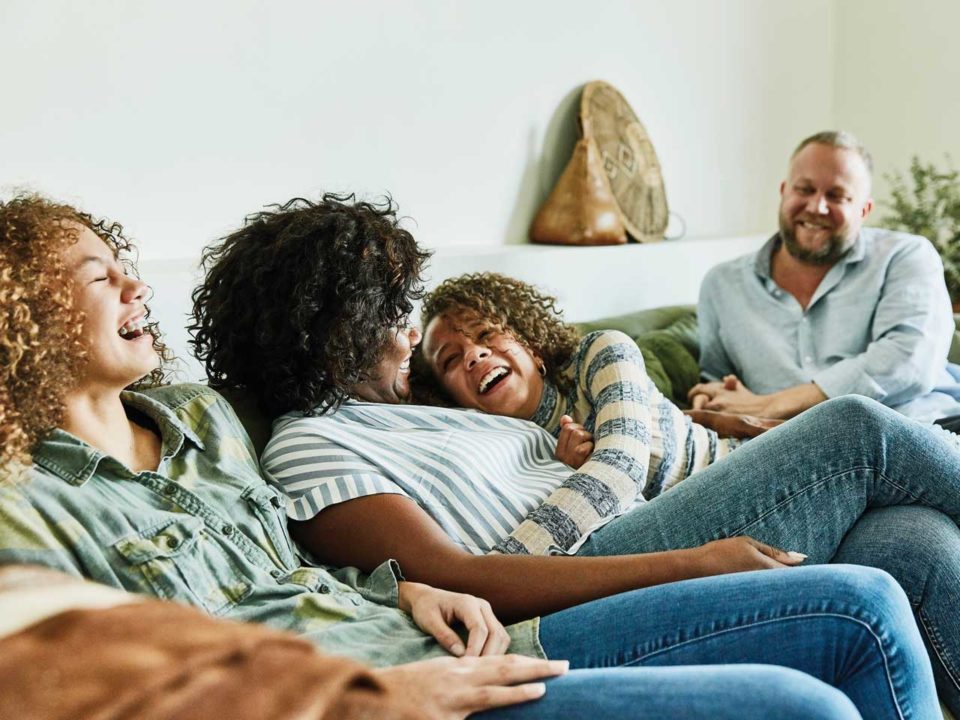 family laughing on couch