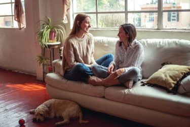 Mother and daughter talking on couch
