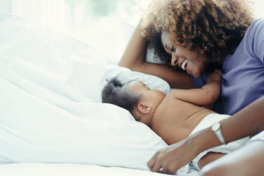 Mother lying in bed with baby girl
