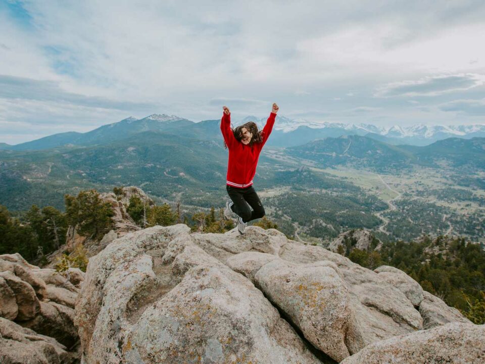 Girl jumping on mountaintop