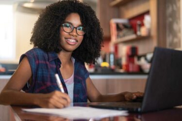 Teen writing, sitting at computer