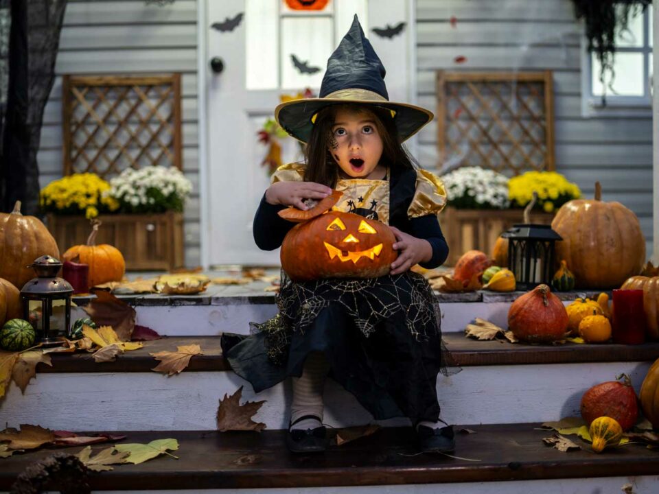 Girl in witch costume on front porch