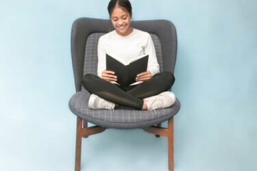 Girl reading a book in chair