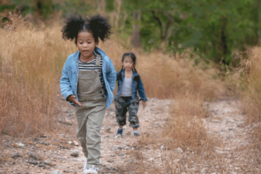 Two children on a hike in the woods