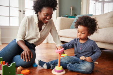 mom playing with her kid, teaching him to match shapes to correct colors